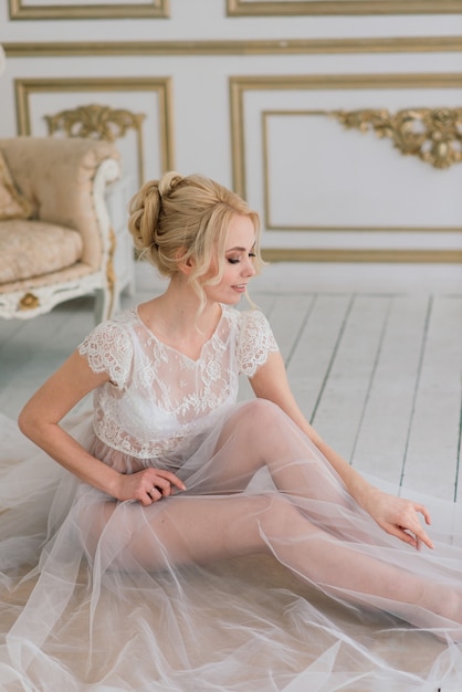 Mañana de una bella joven novia con un vestido de tocador. , interior.