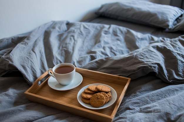 Mañana. Desayuno en la cama. Mantas grises en primer plano