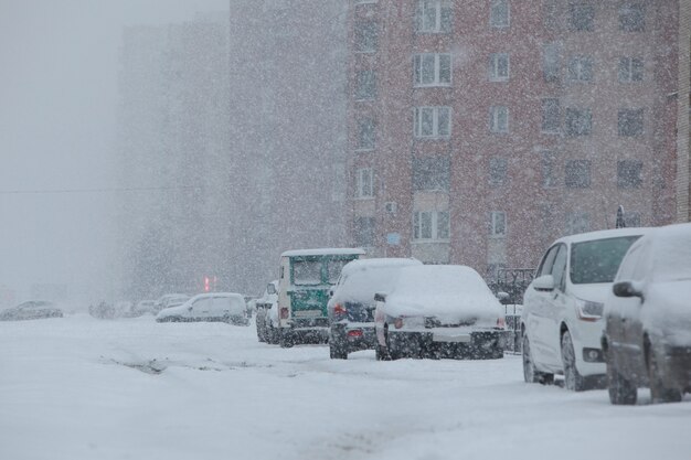 Mañana fría de invierno con nevadas, ventiscas y viento. Ciudad vacía ?????? con autos cubiertos de nieve