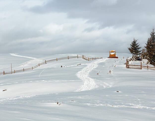 Foto mañana de invierno montaña camino rural cubierto de nieve