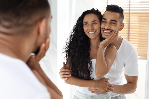 Mañana juntos retrato de feliz joven pareja del Medio Oriente abrazándose en el baño