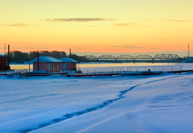 Mañana a orillas del Ob Un banco cubierto de nieve de un gran río un puente ferroviario Novosibirsk