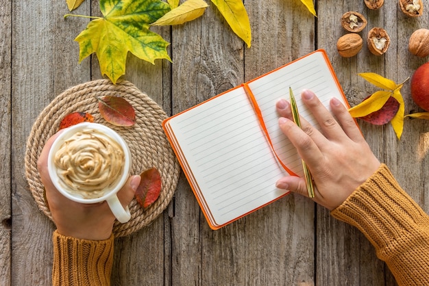 Foto en una mañana de otoño, una niña toma notas en un cuaderno.