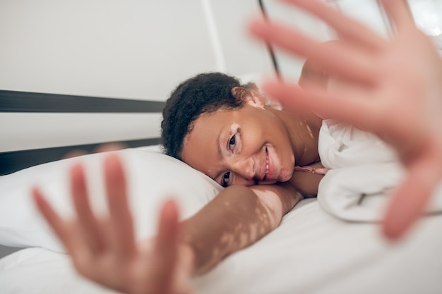 Mañana pacífica. Mujer joven acostada en la cama y sentirse en paz