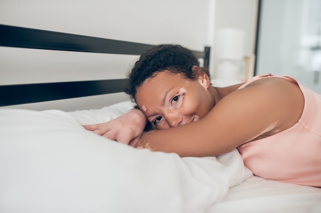 Mañana pacífica. Mujer joven acostada en la cama y sentirse en paz