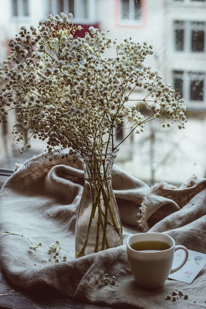 por la mañana té caliente y café un ramo de flores blancas