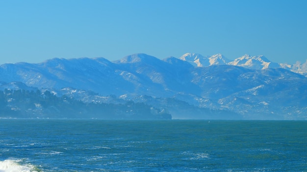 Mañana vacaciones frías de invierno europeo mar y bosque montañas en el fondo tiempo real