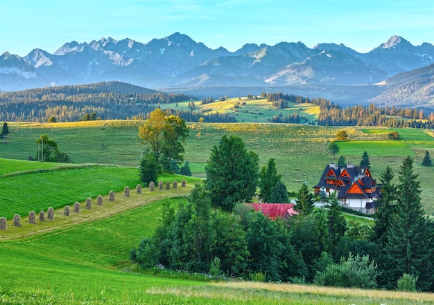 Mañana de verano nebulosa vista de la aldea de montaña y detrás de la gama de Tatra (Gliczarow Gorny, Polonia)