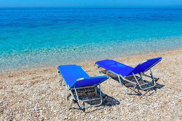 Mañana de verano playa de guijarros con hamacas (Albania).