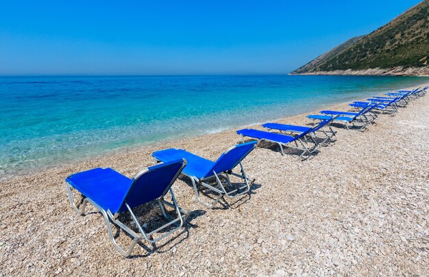 Mañana de verano playa de guijarros con hamacas (Albania).