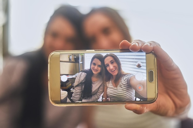 Las mañanas pueden ser para selfies Captura recortada de dos mujeres jóvenes tomando una foto por la mañana en casa