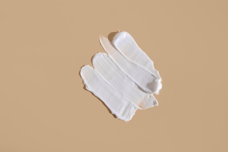 Mancha branca de creme cosmético sobre fundo bege Textura cremosa de fundação isolada