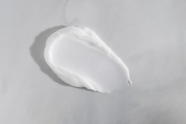 Mancha branca de creme de beleza em fundo de mármore Textura cosmética de produtos para cuidados com a pele