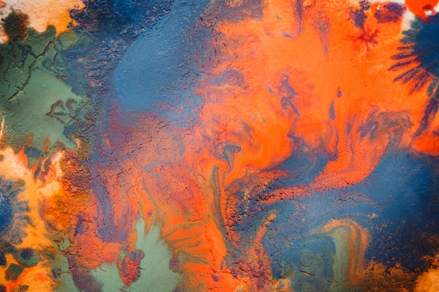 Manchas de tinta multicolorida goteja respingos se misturando. Fundo abstrato