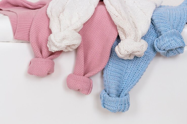 Foto manchas enrolladas de suéteres femeninos de punto cálidos sobre tela cálida de fondo blanco