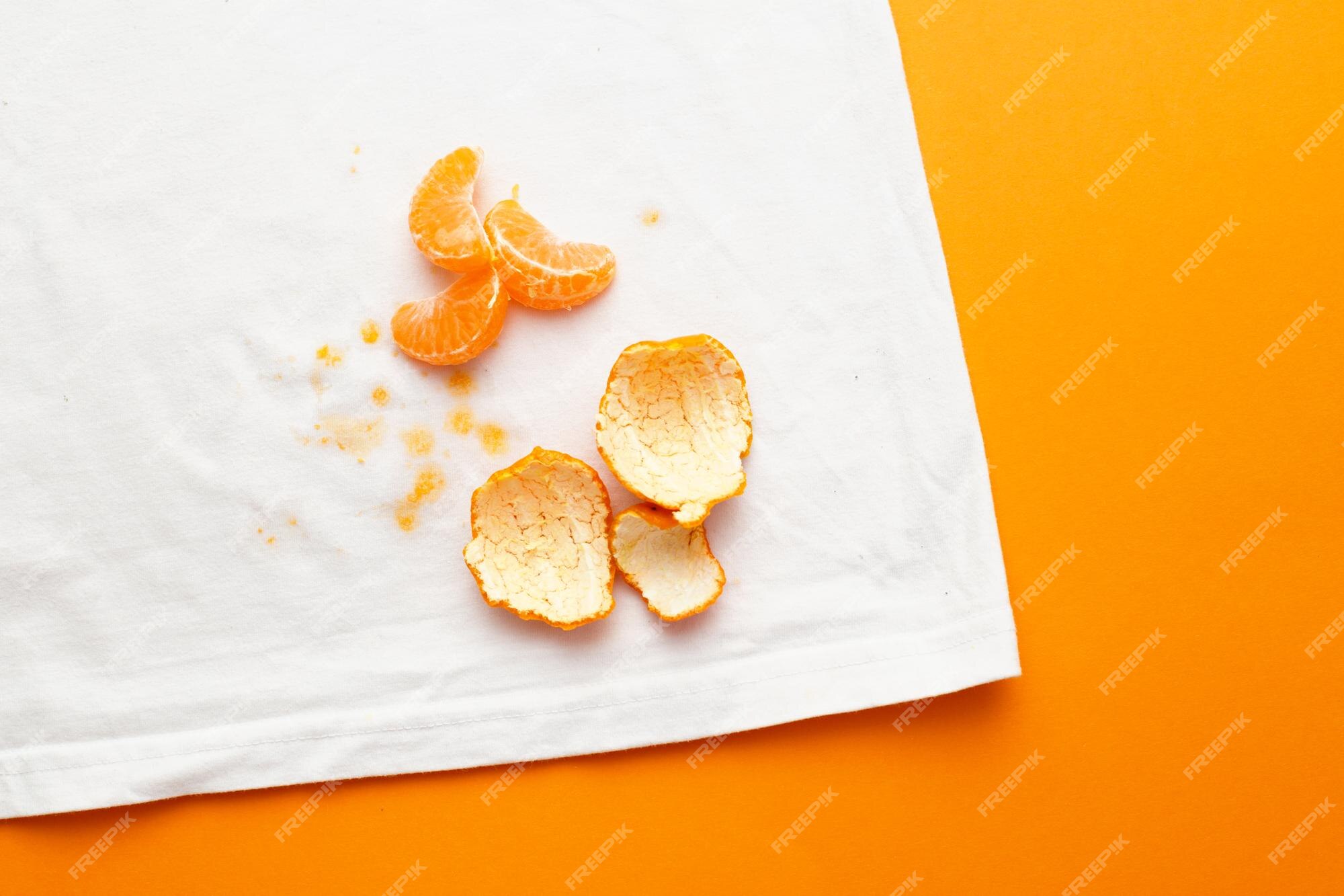 Manchas sucias en ropa blanca de frutas mandarina sobre fondo naranja |  Foto Premium