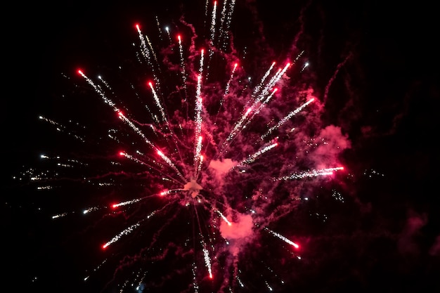 Manchas vermelhas de fogos de artifício na fumaça em um fundo preto Fundo festivo