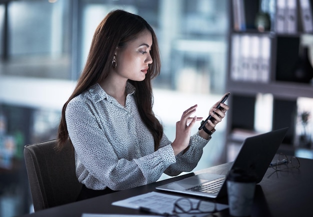 Manchmal braucht der Erfolg etwas mehr Zeit Aufnahme einer jungen Geschäftsfrau, die nachts in einem Büro mit einem Mobiltelefon arbeitet