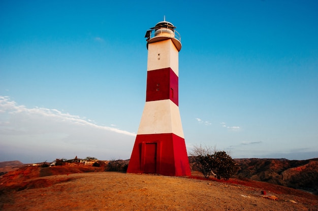 Foto máncora, piura, perú - abril de 2019 faro de máncora sobre la montaña en un atardecer nublado.