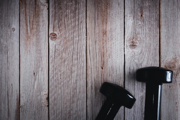 Mancuernas negras para fitness sobre fondo de madera Accesorios de gimnasio Espacio de copia Enfoque selectivo