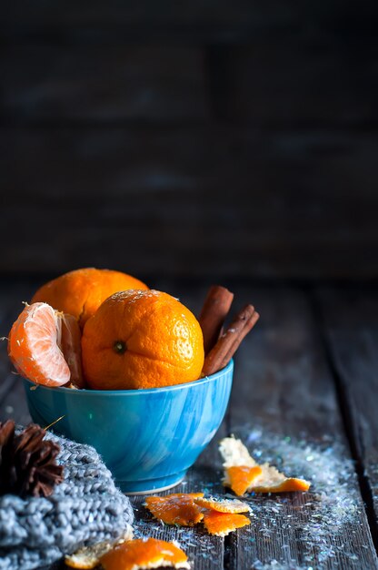 Mandarina en bufanda sobre fondo de madera