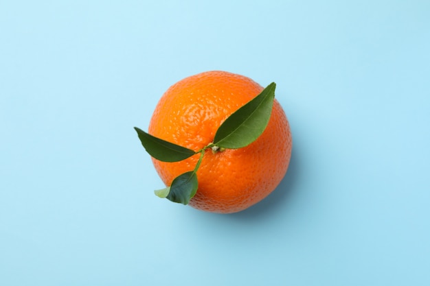 Mandarina madura con hojas en azul