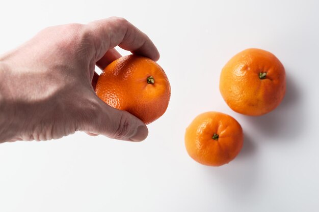 Una mandarina madura en la mano de un hombre