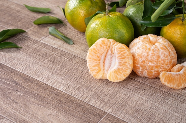 Foto mandarina mandarina madura fresca en una caja con hojas frescas.