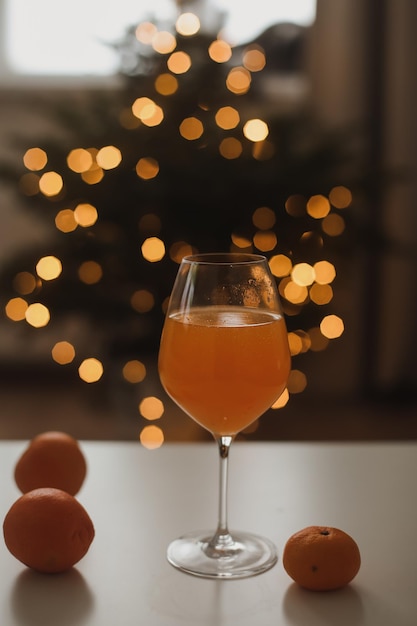 Mandarina o jugo de naranja con mandarinas en el fondo del árbol de Navidad