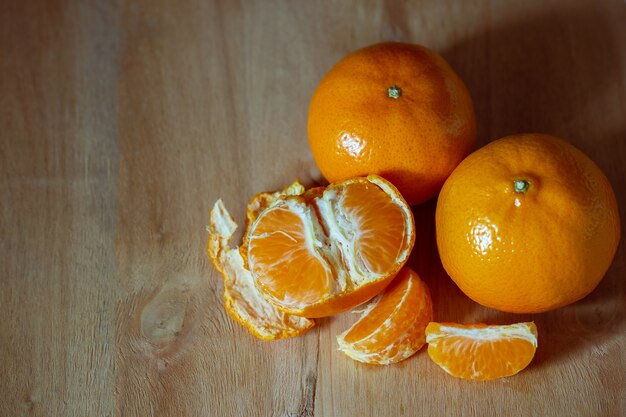 Mandarina pelada en una mesa de madera. El concepto de amor y cuidado de la salud.