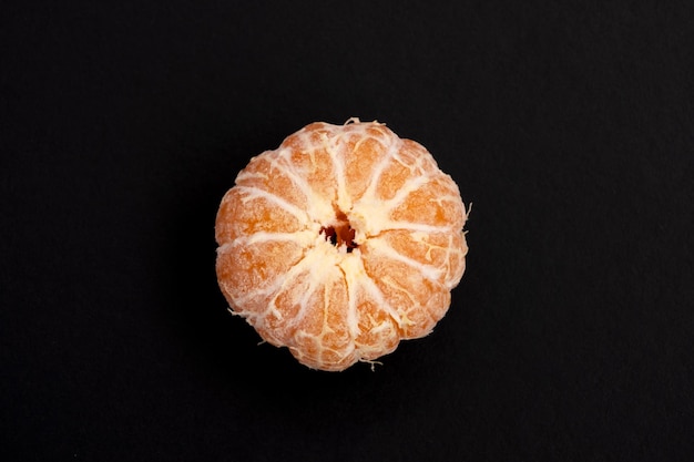 mandarina pelada sobre fondo negro