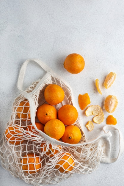 mandarinas en una bolsa de hilo en una vida ecológica blanca