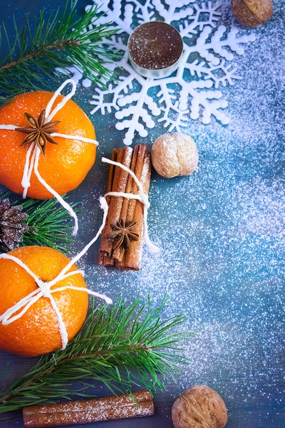 Mandarinas, canela, nueces y copos de nieve como decoración navideña.