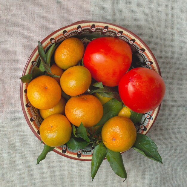 Mandarinas y caquis se encuentran en un hermoso plato.