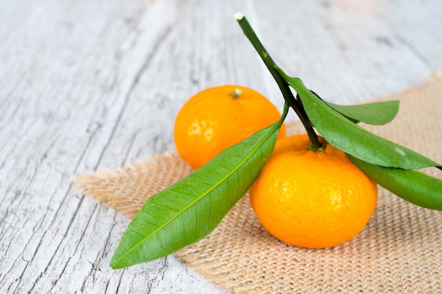 Mandarinas clementinas tangerinas em mesa rústica de madeira com folhas