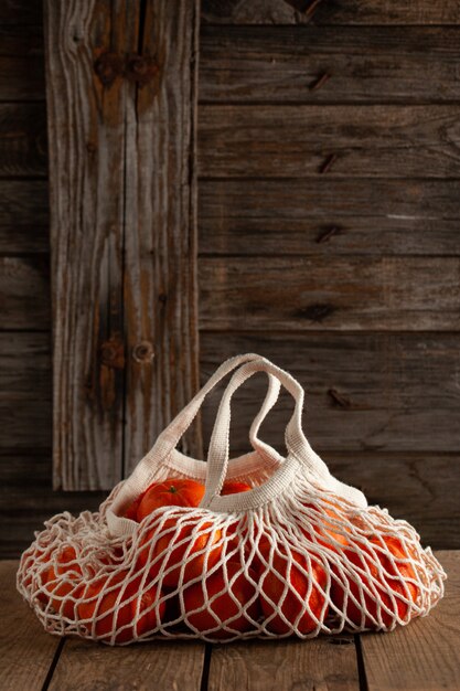 Foto mandarinas frescas en una bolsa de hilo cerrar