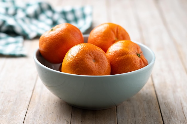 Mandarinas frescas en un cuenco en una mesa de madera