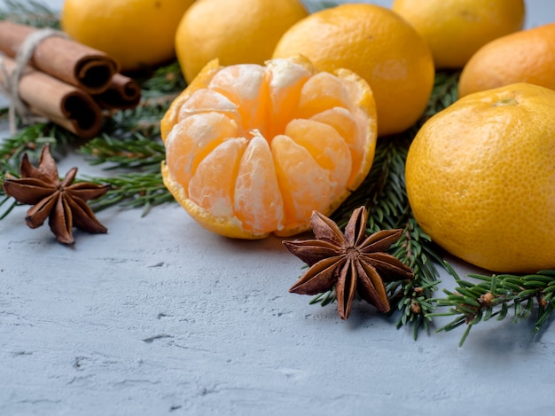 Mandarinas frescas con ramas de árbol de Navidad, anís estrellado, canela sobre hormigón gris