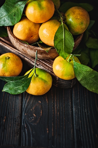 Mandarinas con hojas en una mesa de campo antigua