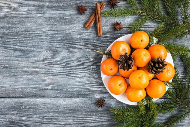 Mandarinas en madera con ramas de abeto navideño