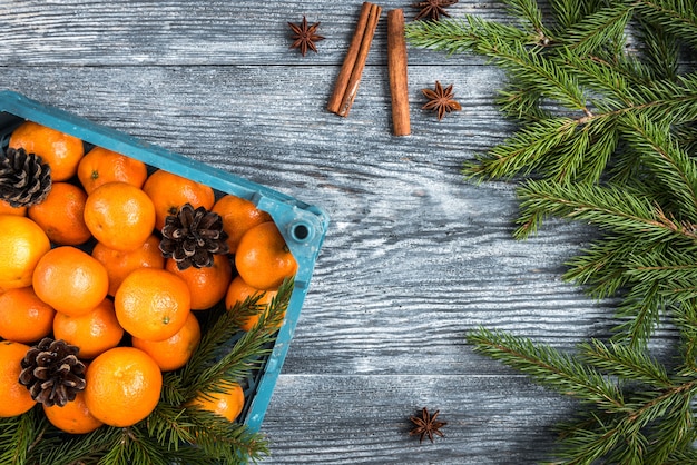 Mandarinas en madera con ramas de abeto navideño