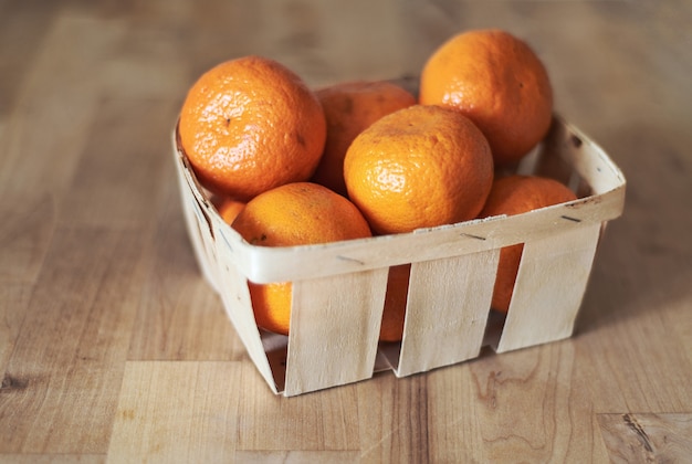 Mandarinas maduras en una canasta de madera