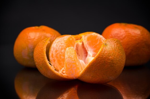 mandarinas maduras com casca em fundo preto
