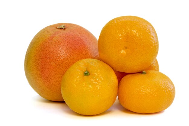 Mandarinas maduras y pomelo sobre un fondo blanco.