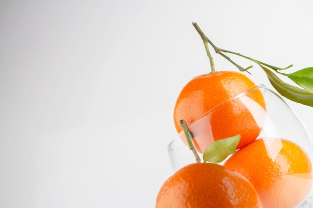 Mandarinas maduras y vidrio transparente para jugo Primer plano de fondo de alimentos