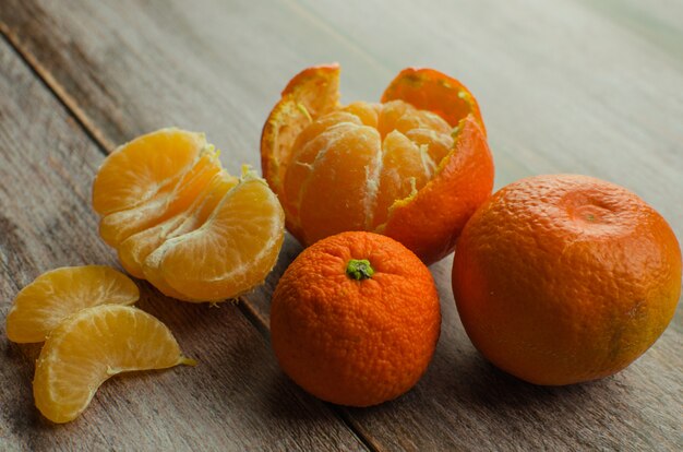 Mandarinas, mandarina pelada y rodajas de mandarina en una mesa de madera blanca. copia espacio