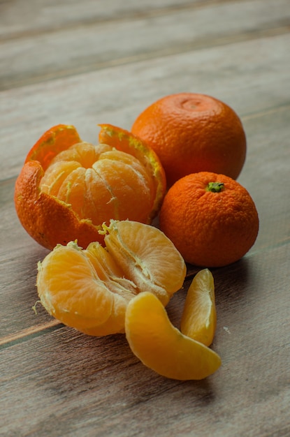 Mandarinas, mandarina pelada y rodajas de mandarina en una mesa de madera blanca. copia espacio