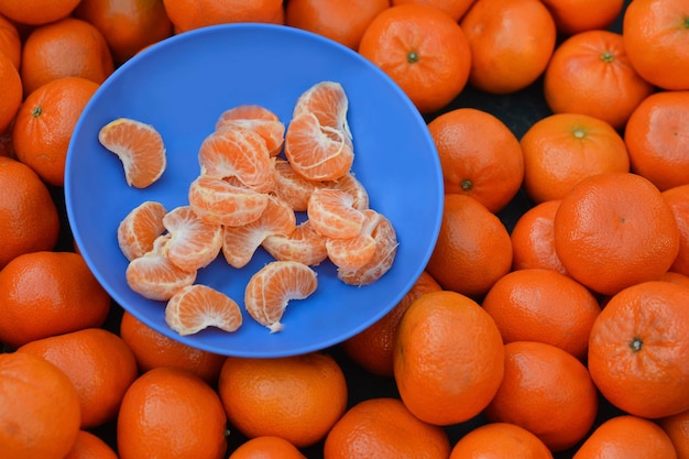 Mandarinas na placa de mercado com fatias de tangerina para degustação