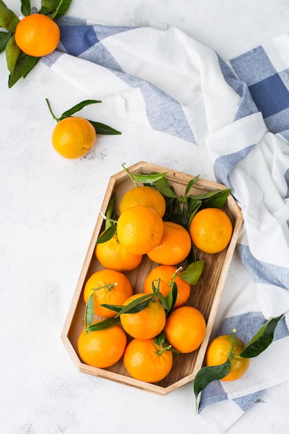 Mandarinas naranjas orgánicas frescas y jugosas mandarinas con hojas verdes en una mesa de cocina Concepto de comer vitaminas saludables