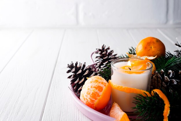 Mandarinas navideñas con vela encendida.